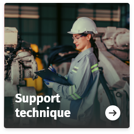 Technicienne équipée d’un casque de sécurité utilisant une tablette devant une machine industrielle en atelier